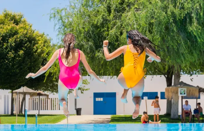 Deux adolescentes sautant dans une piscine