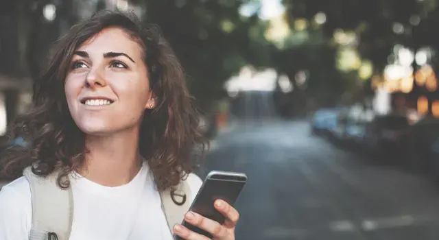 Jeune femme souriante avec un smartphone à la main