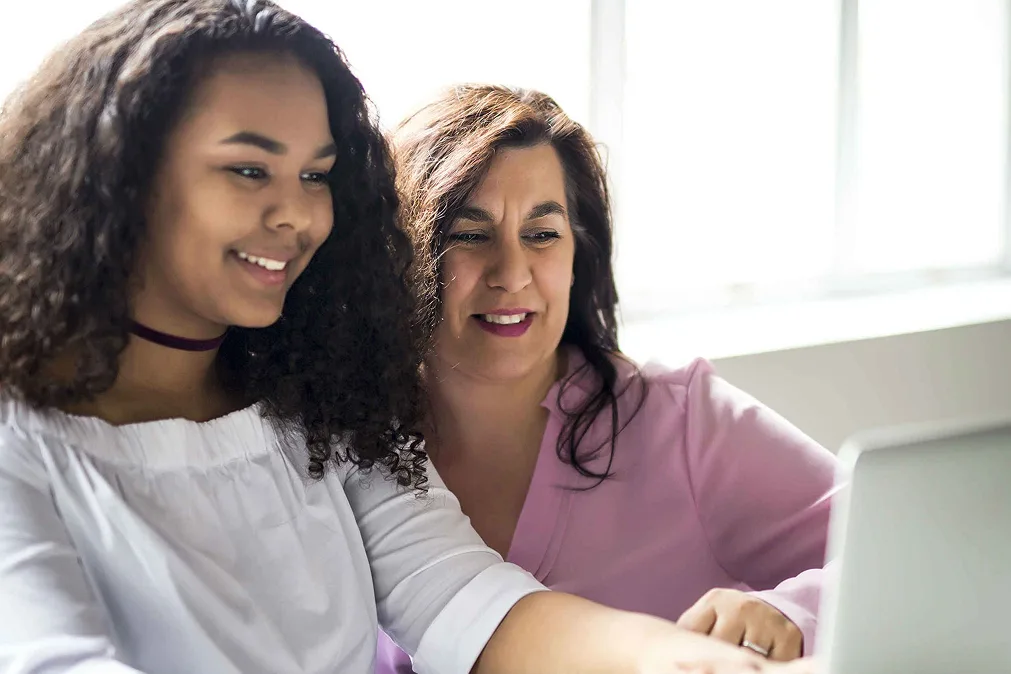 Mom and daughter watching in laptop