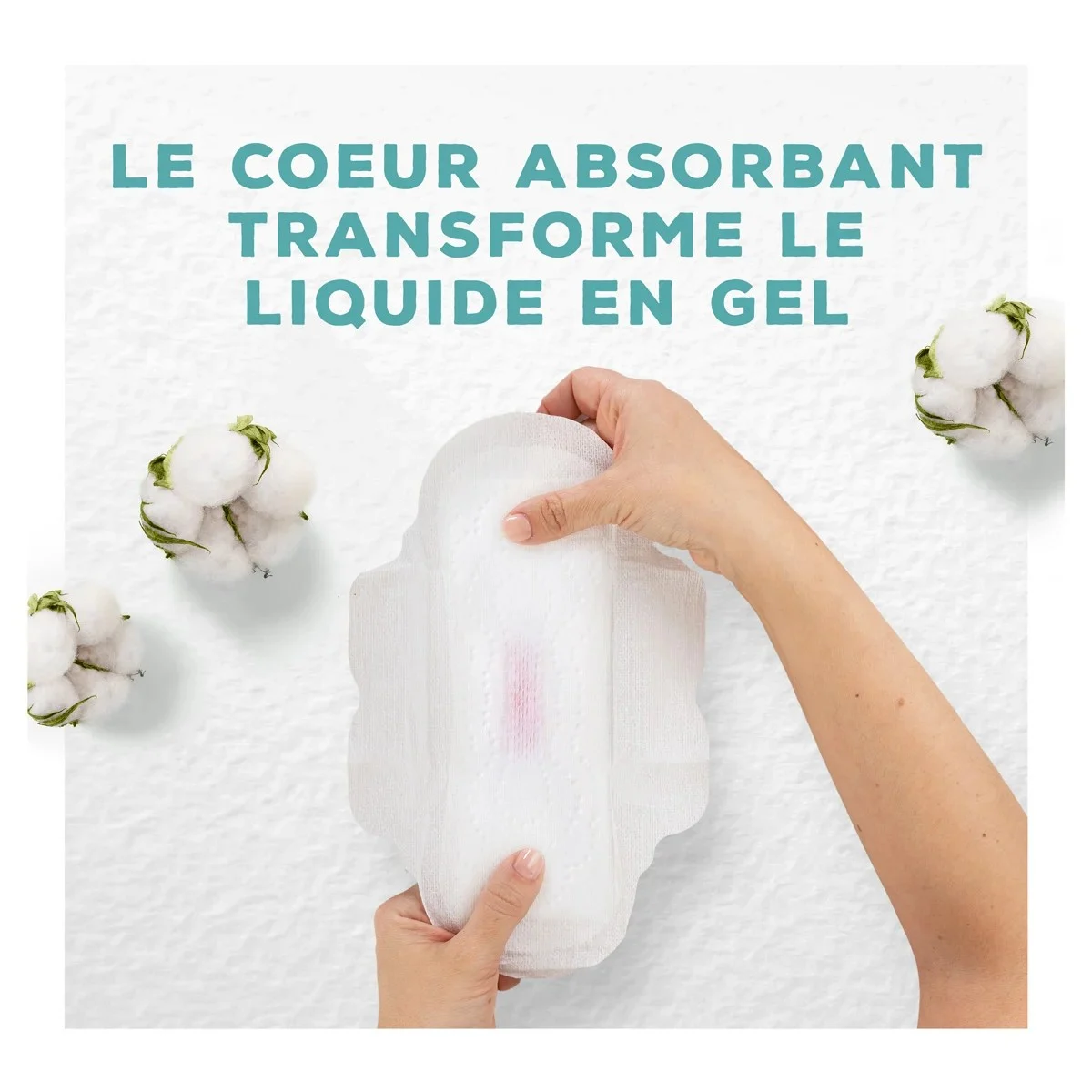 Des mains portant une serviette avec une tache rouge faible pour illustrer le coeur absorbant