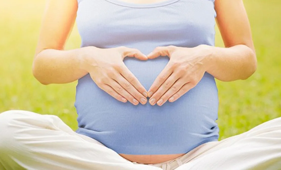 Femme enceinte tenant son ventre