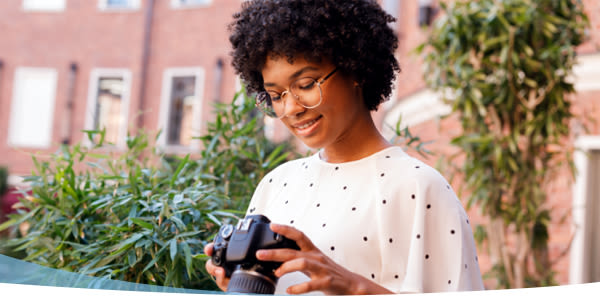 Jeune fille souriante avec un appareil photo