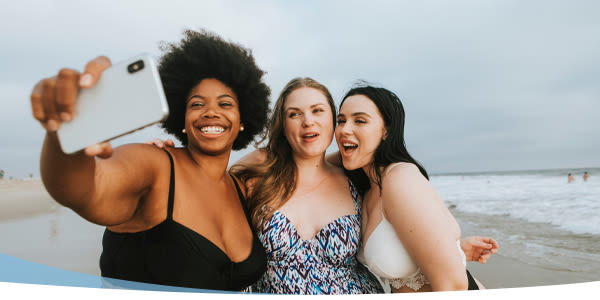 Trois belles femmes prenant le selfie sur la plage