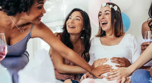 Trois femmes tenant le ventre d'un collègue enceinte 