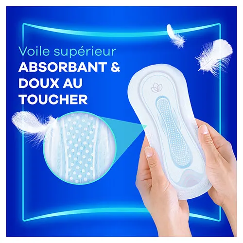 Mains tenant une serviette menstruelle Always Ultra avec une loupe montrant le voile supérieur absorbant et doux au toucher
