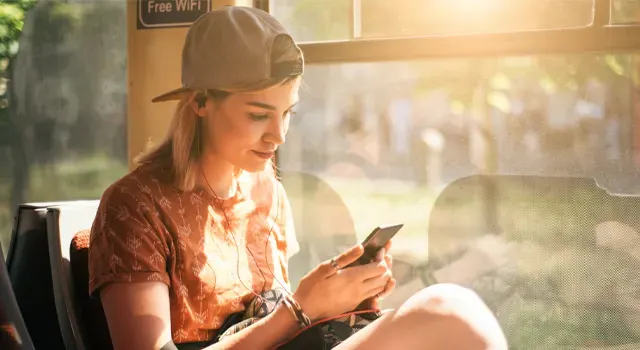 Jeune fille dans le bus avec un smartphone à la main