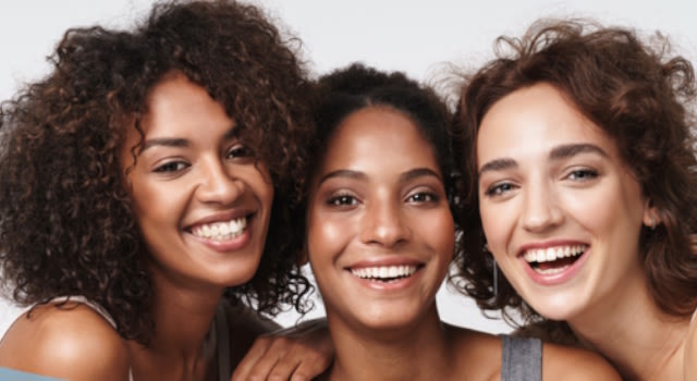 Trois jeunes femmes souriantes  