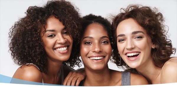 Trois jeunes femmes souriantes  