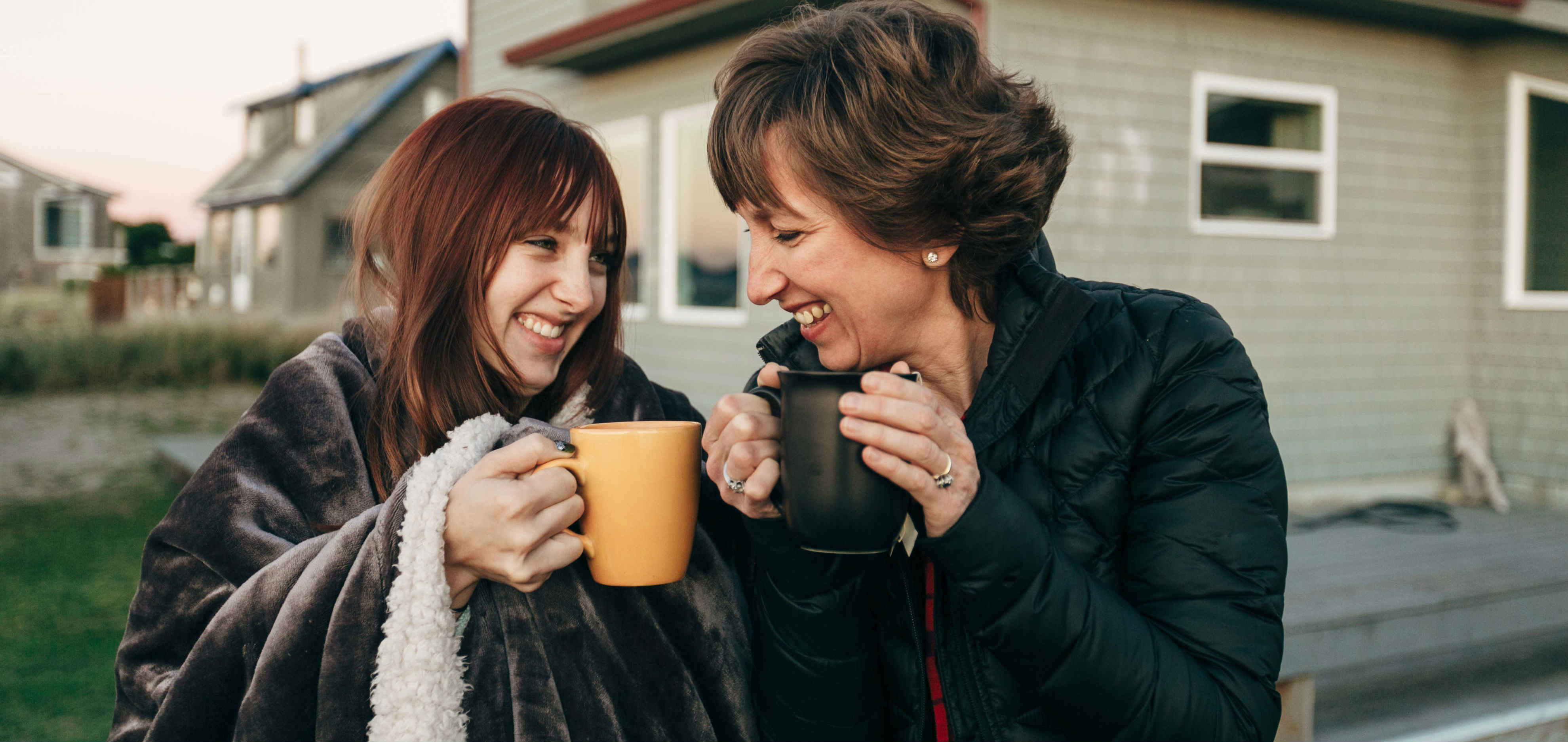 Maman et fille avec une tasse de thé sont debout à l'extérieur