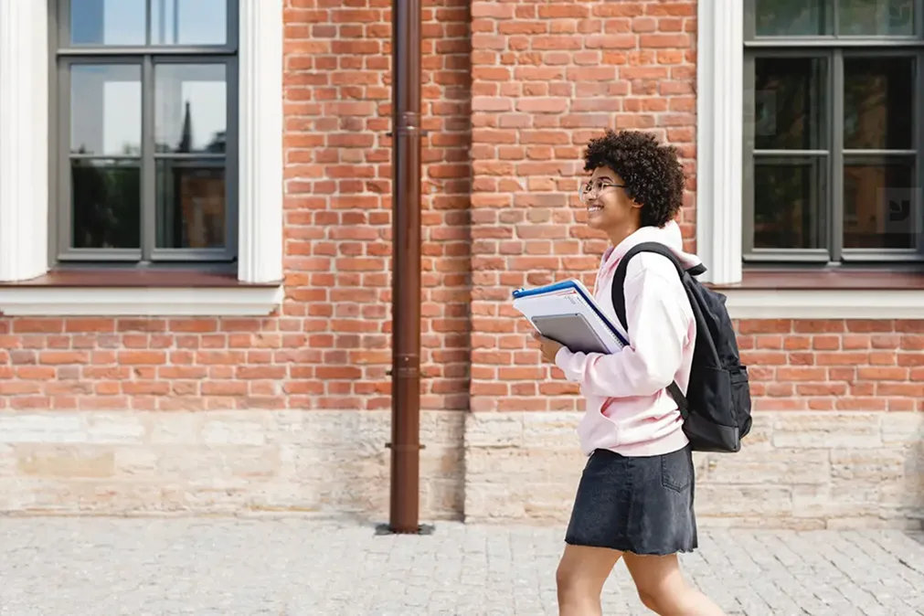 Jeune fille souriante va à l'école
