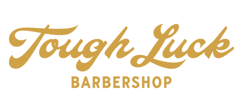 Script style logo for Tough Luck Barbershop in a mustard tone