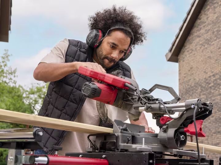 Man in een tuin die een tafelcirkelzaag van SKIL gebruikt