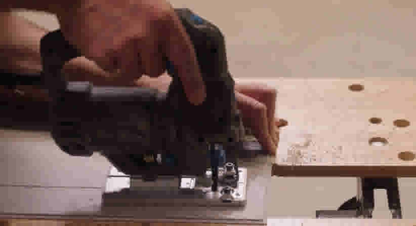 Decoupeerzaag zaagt een clickvinylvloer op maat op een werkbank