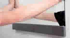 Man monteert spiegel aan de muur in badkamer