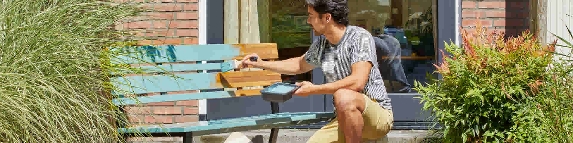 Man schildert bank buiten