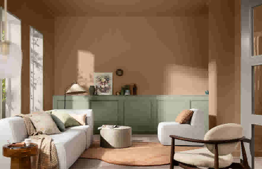 Salon moderne avec murs beiges, lambris vert sauge, canapé gris clair, fauteuil beige et lumière naturelle douce.