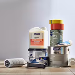 Verschillende emmers en potten verf met schilderstape, voorstrijk, muurvuller en een verfroller