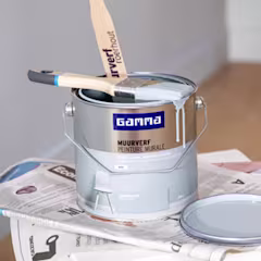 Lichtblauwe muurverf met verfborstel bovenop