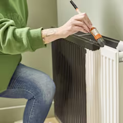 Vrouw die radiator zwart verft