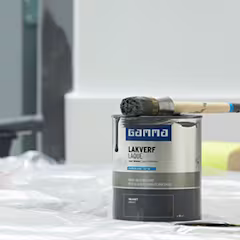 Pot de peinture avec pinceau posé dessus