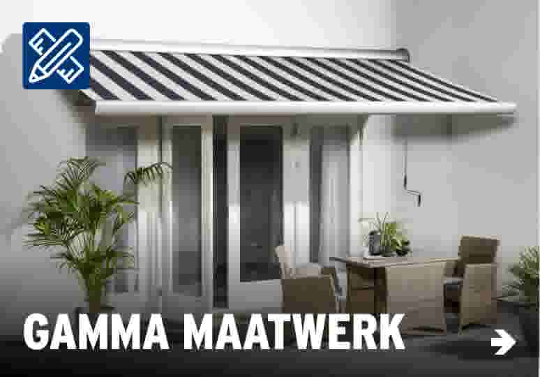 Modern terras met gestreepte zonwering, rieten tuinmeubilair en groene planten tegen een witte muur.
