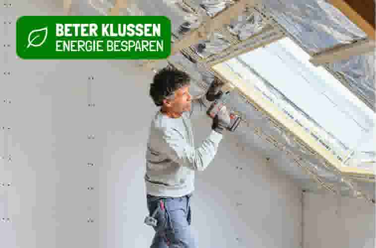 Man installeert dakisolatie met boormachine in zolderruimte met groene energiebesparingsbanner.