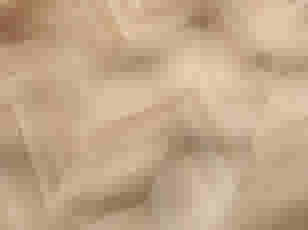 Parquet en bois clair disposé en chevrons, montrant une texture élégante avec des nuances beiges et des veines naturelles.