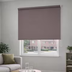 Store enrouleur gris-brun à moitié baissé sur une fenêtre lumineuse, dans un salon moderne avec canapé et table basse.