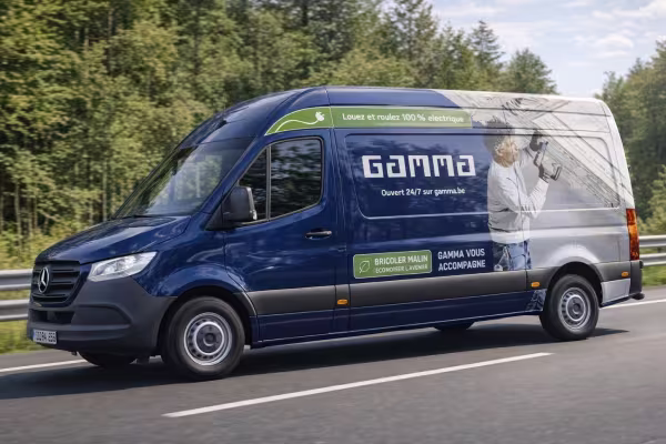 Camionnette bleue Gamma avec image d'un technicien travaillant sur un mur, mention "100% électrique" sur le côté.