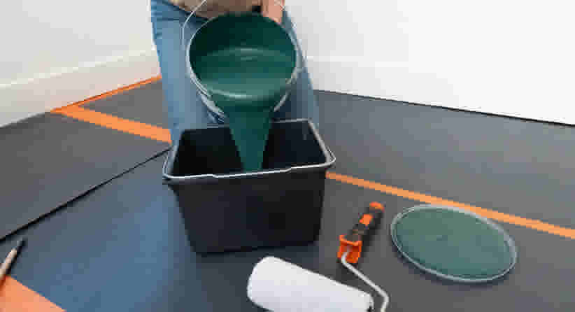 Emmer met groene verf en verfbenodigdheden