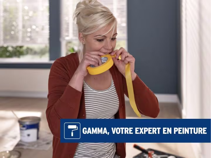 Femme en train de découper un morceau de ruban de masquage