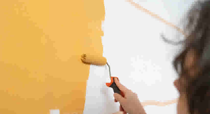 Eerst laag gele verf aanbrengen op muur