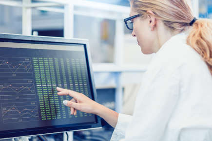 Female scientist looking at computer screen showing epidemiological data.