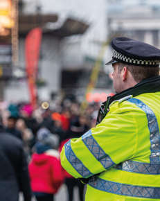 An officer of the London Metropolitan Police standing with his back to the camera.