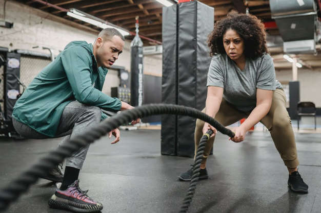 Personal trainer motivating a woman to work out in the gym.