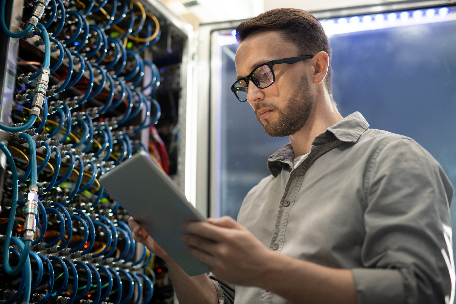Man holds clipboard looking at server.
