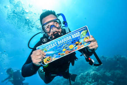 Diver holding up a certificate on the Great Barrier Reef.