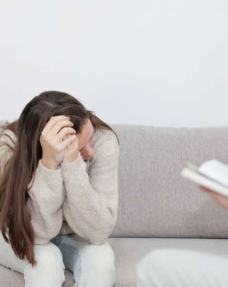 Young woman sitting on the sofa at a psychologist's office.