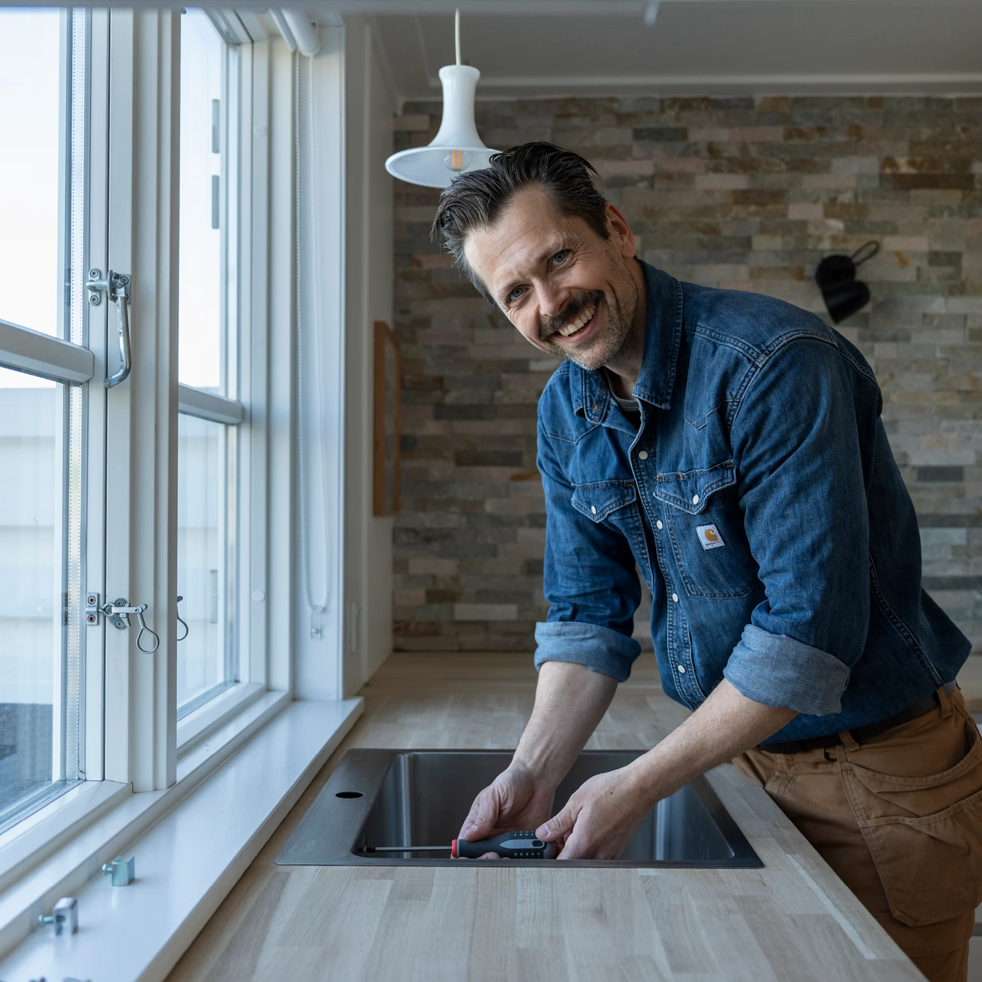 Jacob Carlsson er ved at montere køkkenvask fra VASSO.