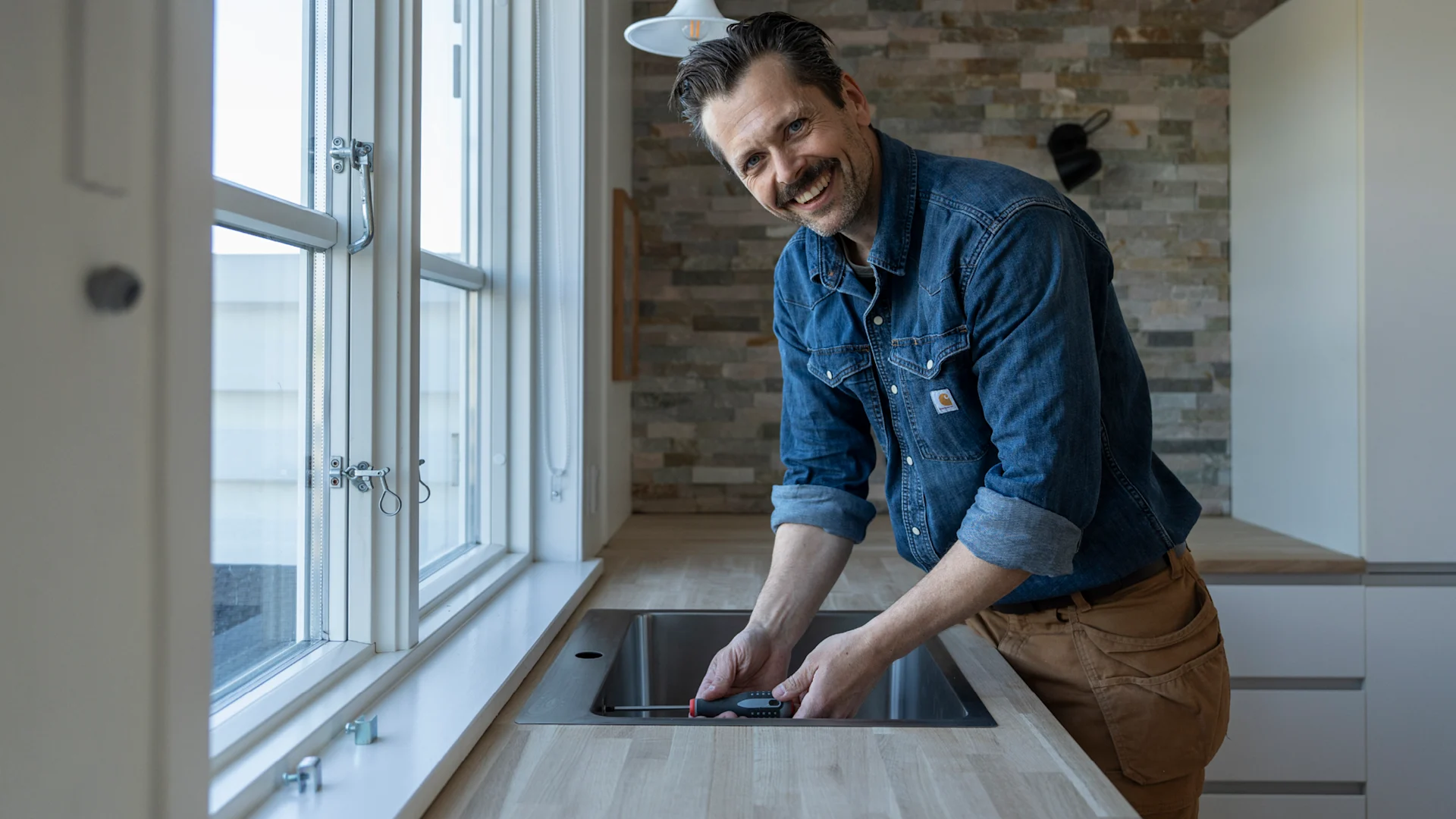 Jacob Carlsson er ved at montere køkkenvask fra VASSO.