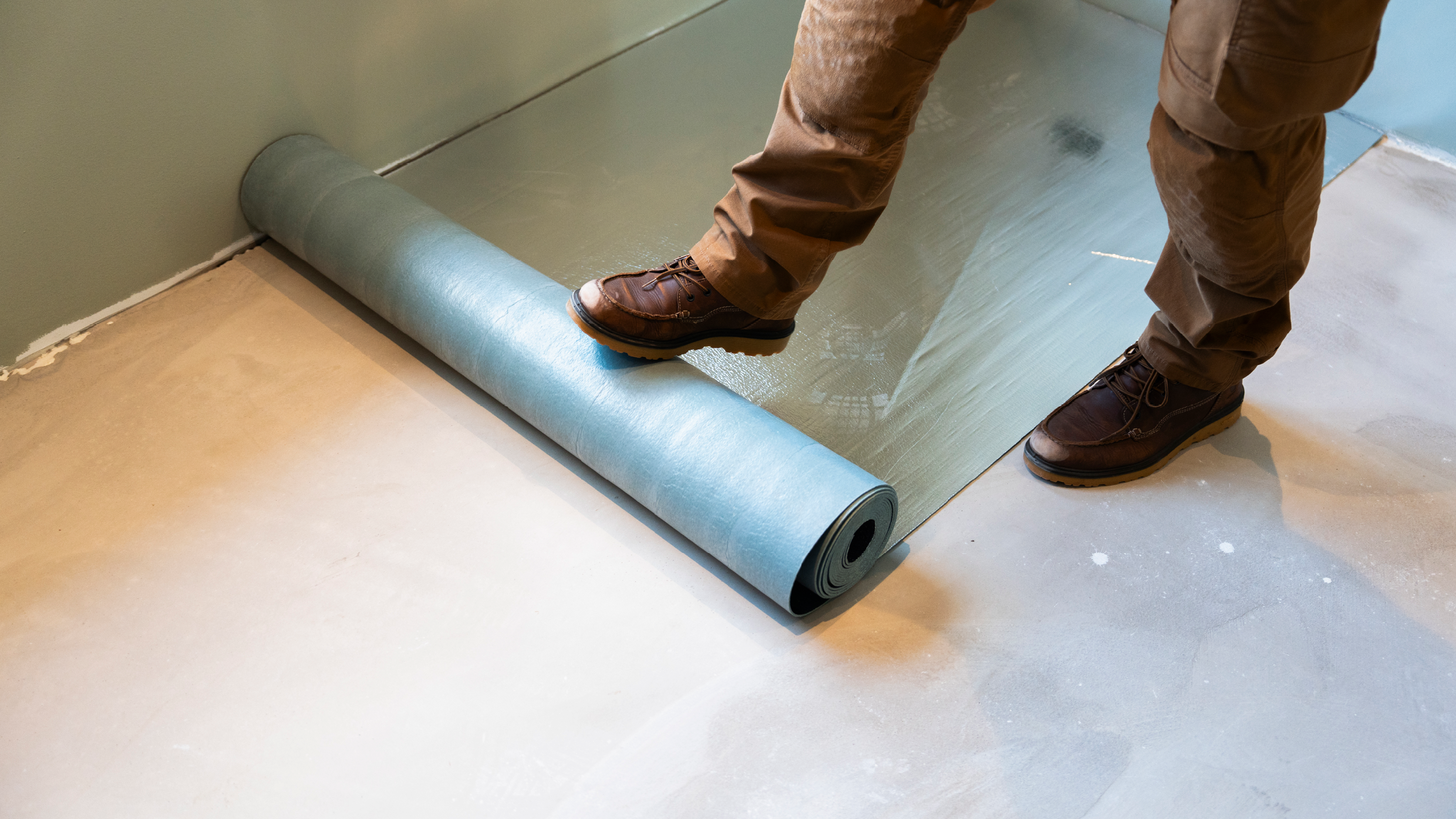 gulvunderlag rulles ud på undergulv