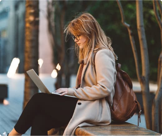 Woman outside studying on laptop