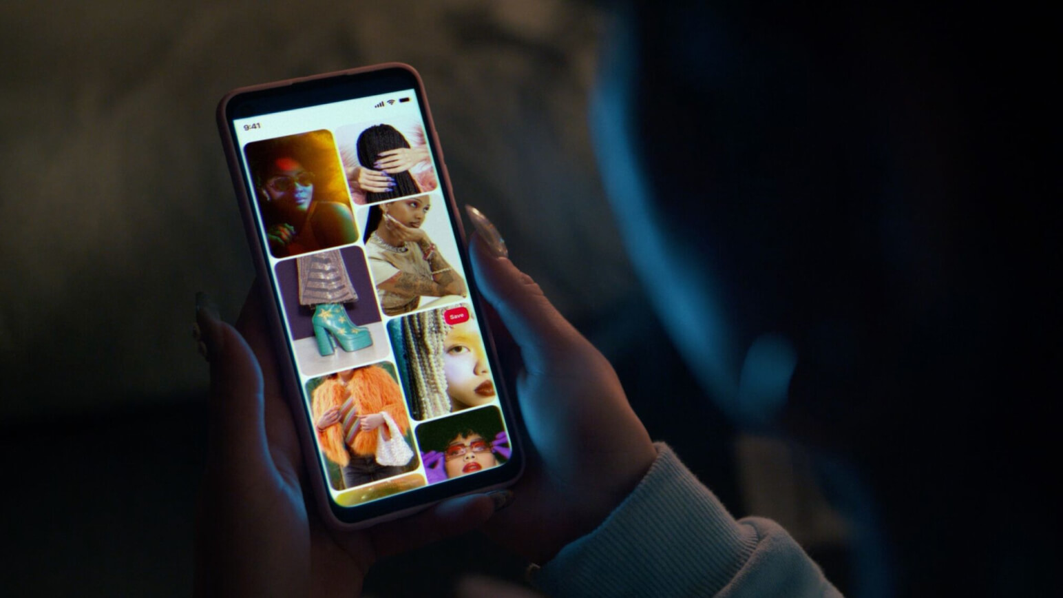 Image of a person’s hand holding a mobile phone, looking at Pinterest