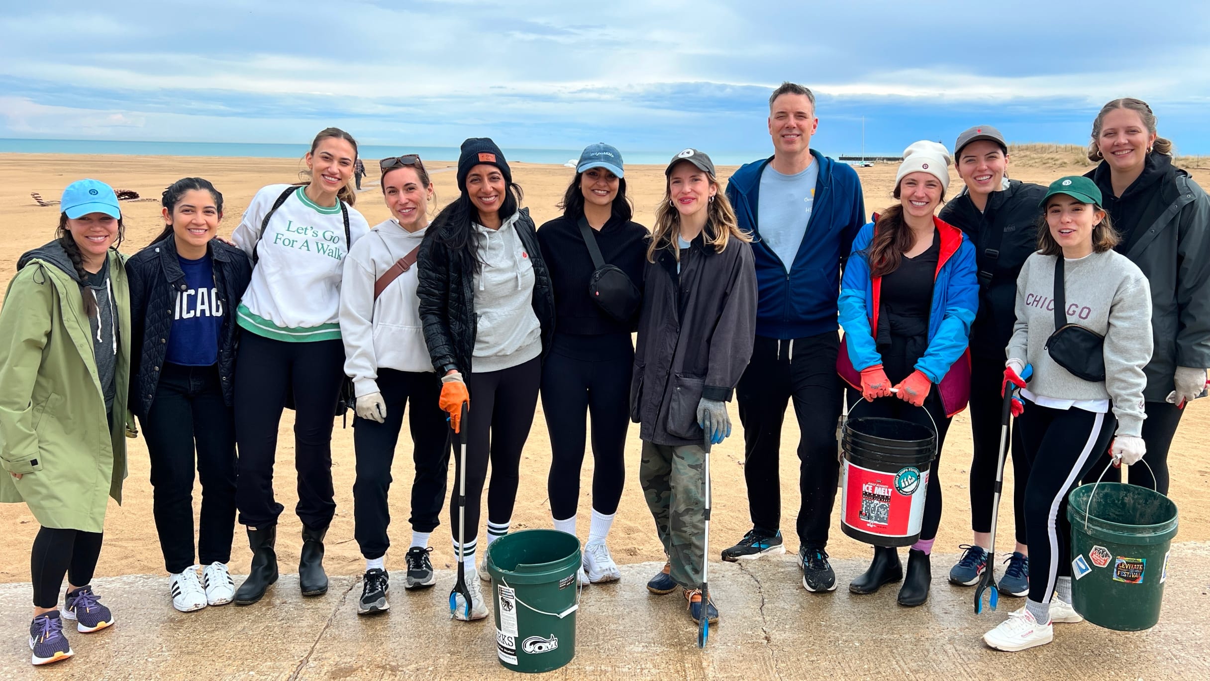 A group of Pinterest employees poses for a photo while cleaning up the beach