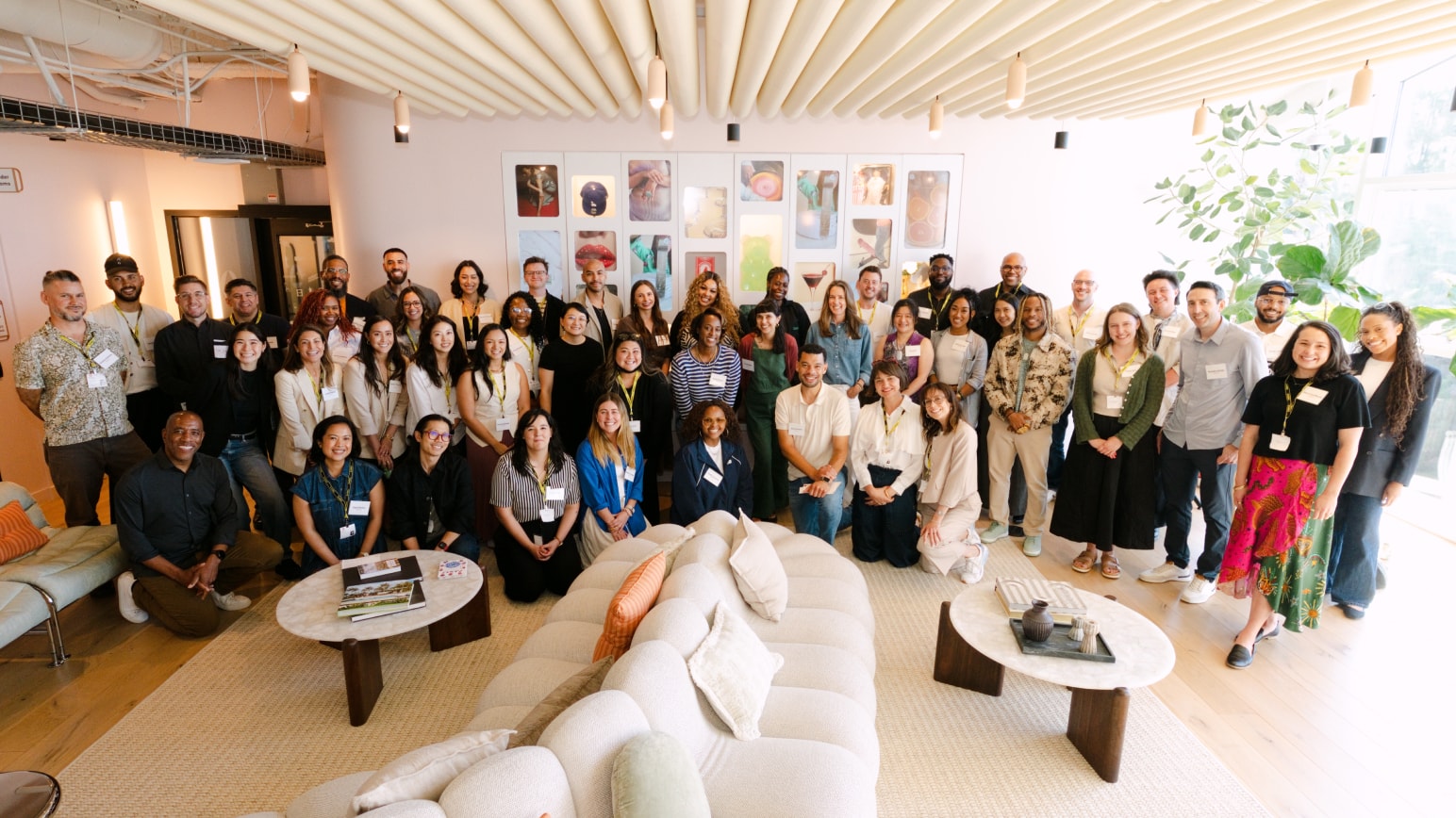 A group photo of people at the Impact Lab Summit posing and smiling together in a modern office space. 