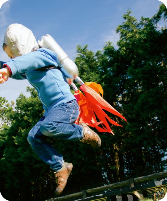 A child jumps in mid-air with a homemade jetpack on his back