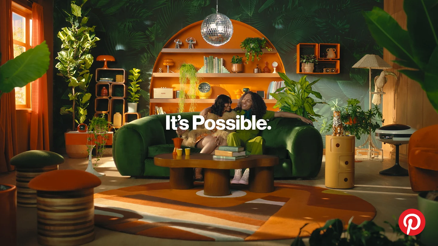 A couple sits on the couch in their jungle-inspired living room