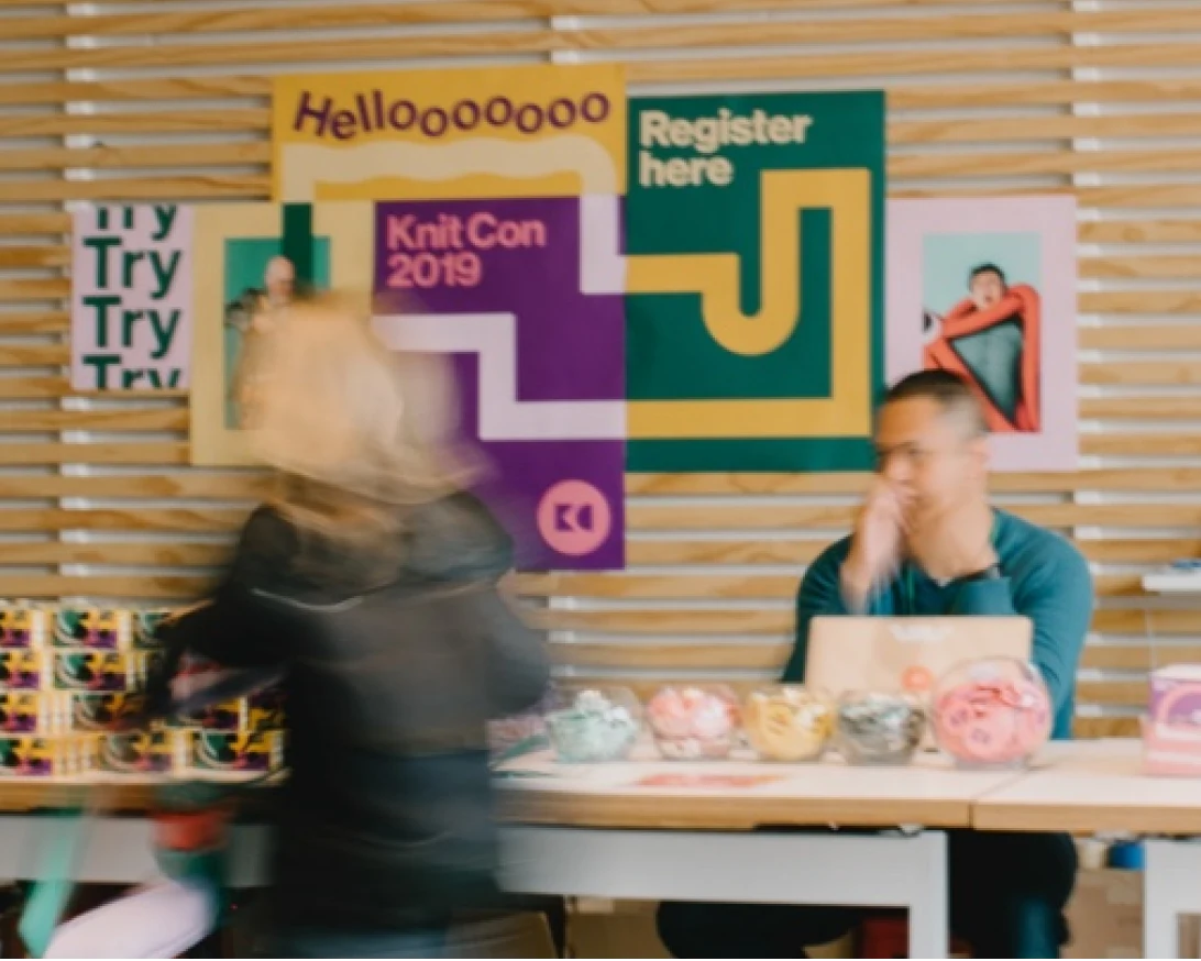 I dipendenti di Pinterest siedono attorno a un tavolo coperto da oggetti colorati. 