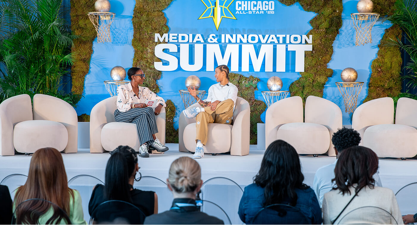 Two people sit on a stage in front of a sign that reads “Chicago All-Star 2026 Media & Innovation Summit.” 