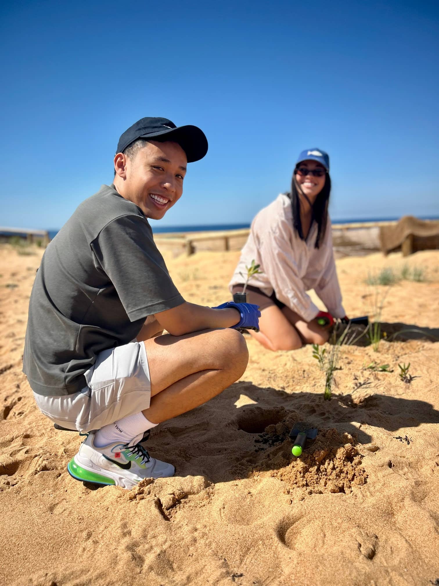 Pinterest employee and Impact Ambassador, Jamie Sayvong, and a colleague cleaning up the beach